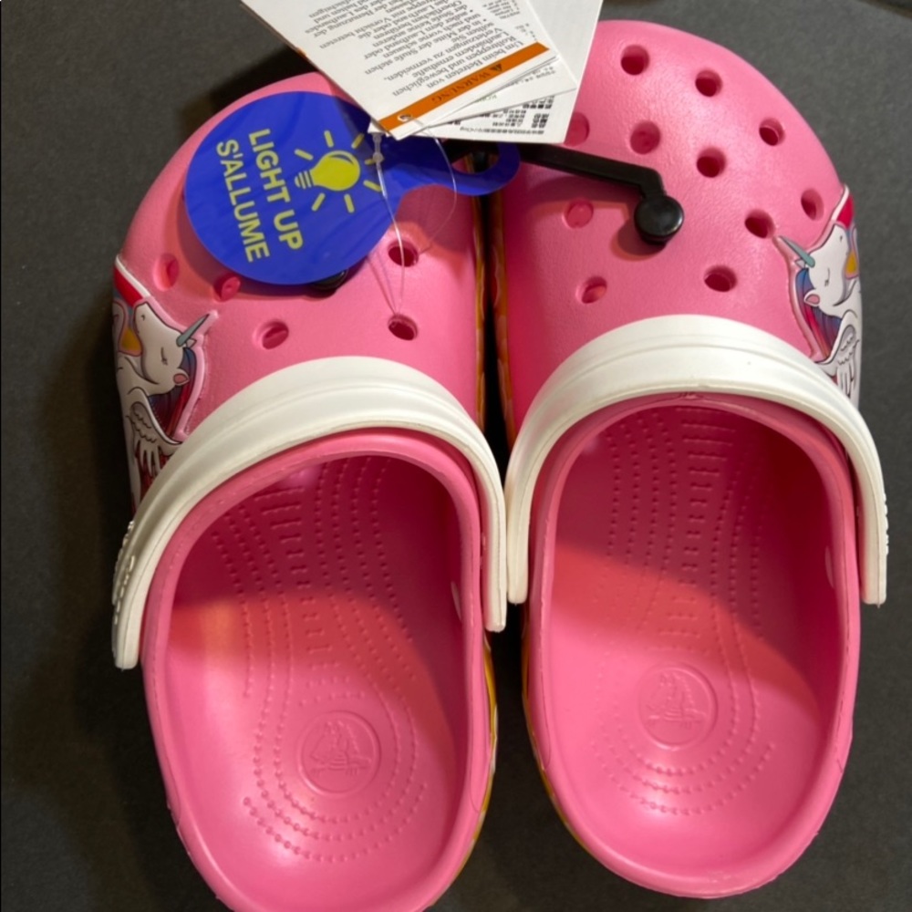 Girls pink Crocs with unicorn and heart design.The hearts light up when walking